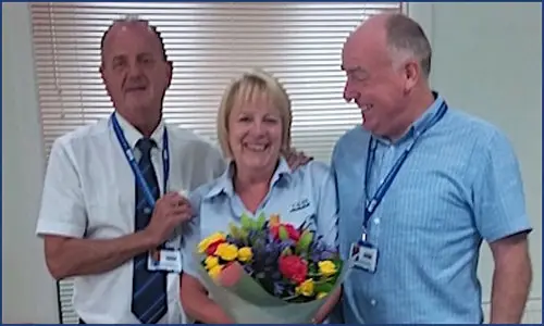 Anne Neilson receiving flowers from Paul Connelly for 25 years service