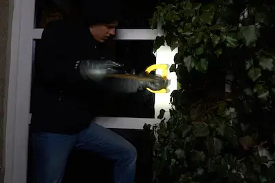 burglar trying to get into a house using a crowbar - in motion