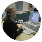 young woman wearing telephone headset at PC in office