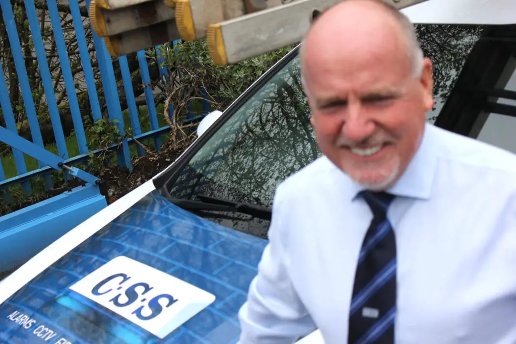 Photo of Paul Connelly next to a CSS branded car. Paul is in the foreground and blurred and the car is in normal field of vision.