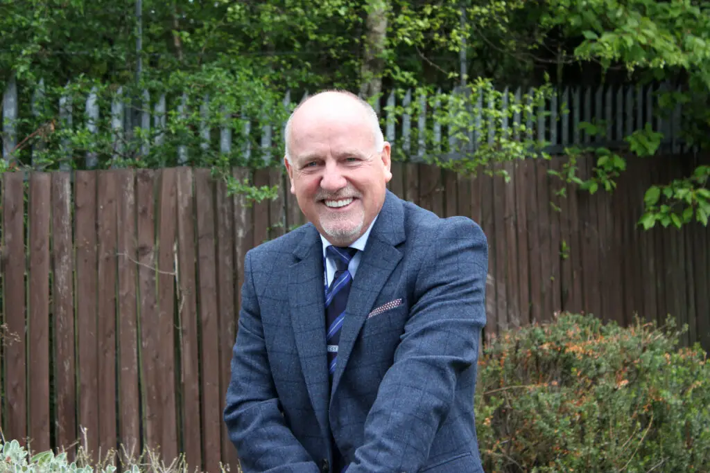 Photo of Paul Connelly smiling in garden location.