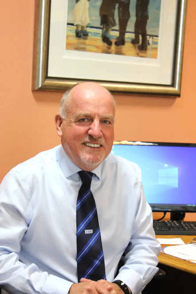 Paul Connelly smiling and sitting in his office in front of a PC.
