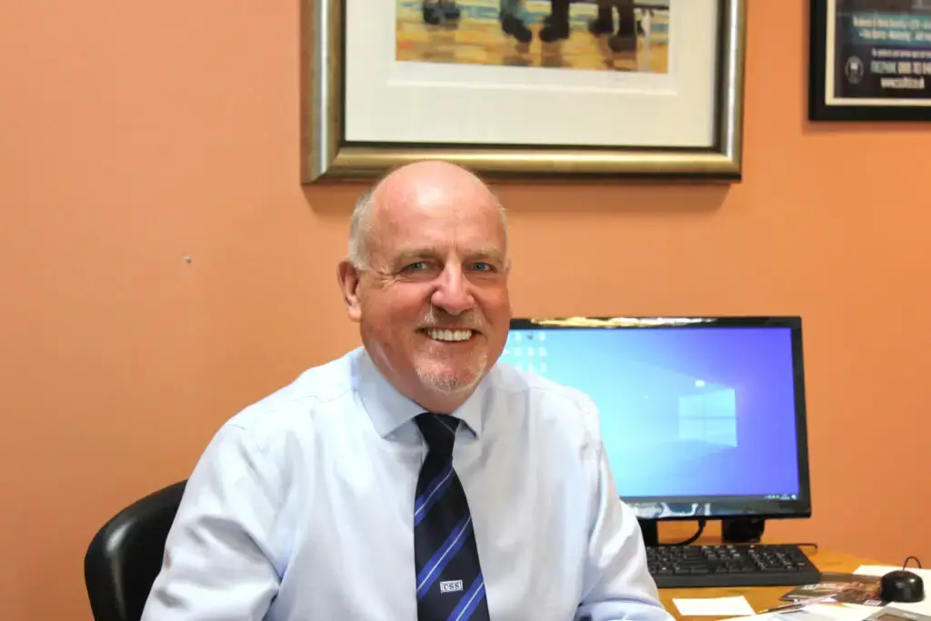 Paul Connelly smiling and sitting in his office in front of a PC.