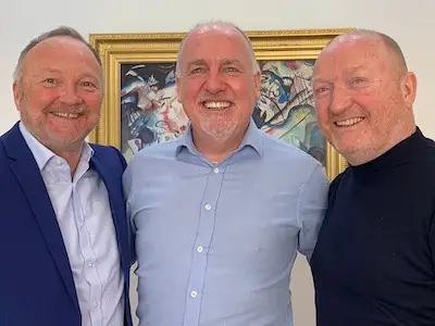 Photo of Paul Connelly smiling alongside two colleagues.
