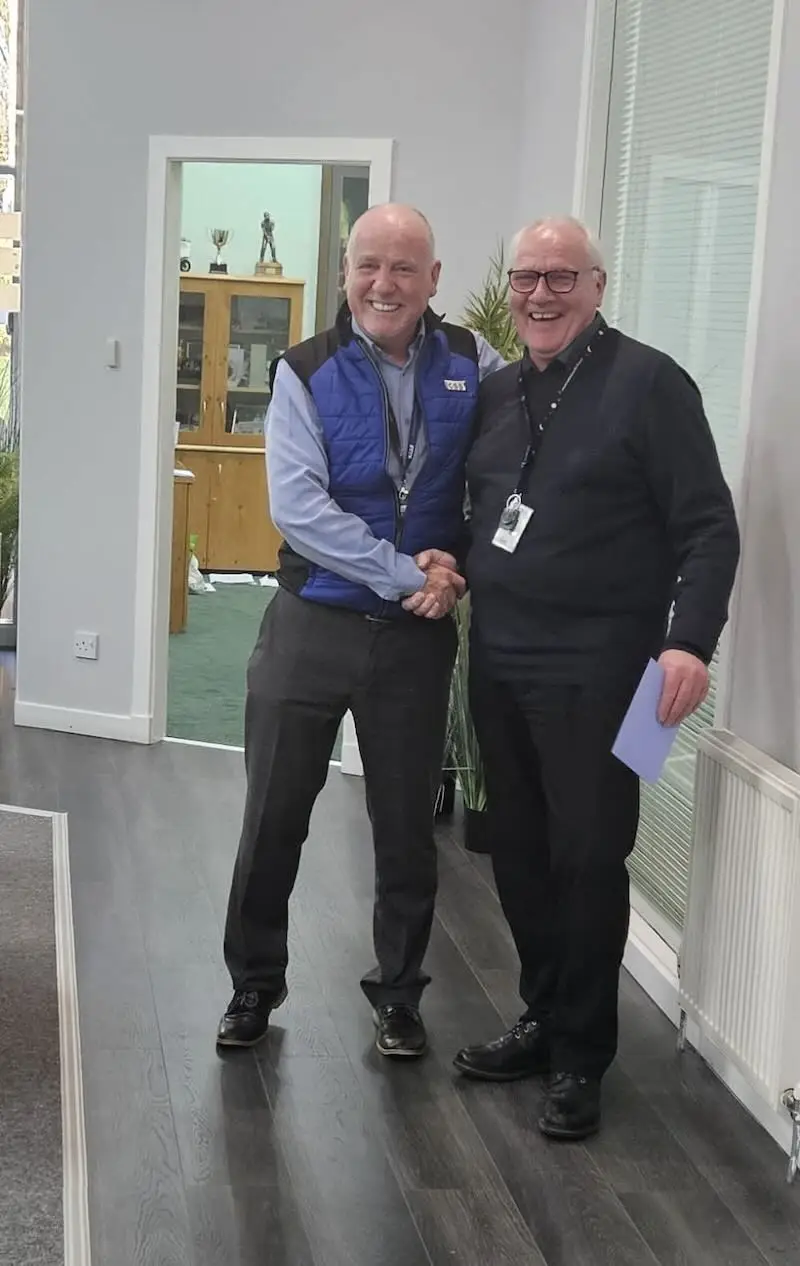 Paul Connelly shaking hands with John McDaid, both smiling - css celebrates john mcdaid work anniversary